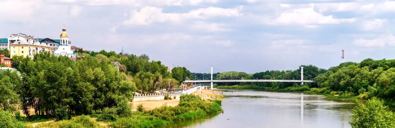 orelburg ural river in the summer cityscape with river promenade beach and bridge
